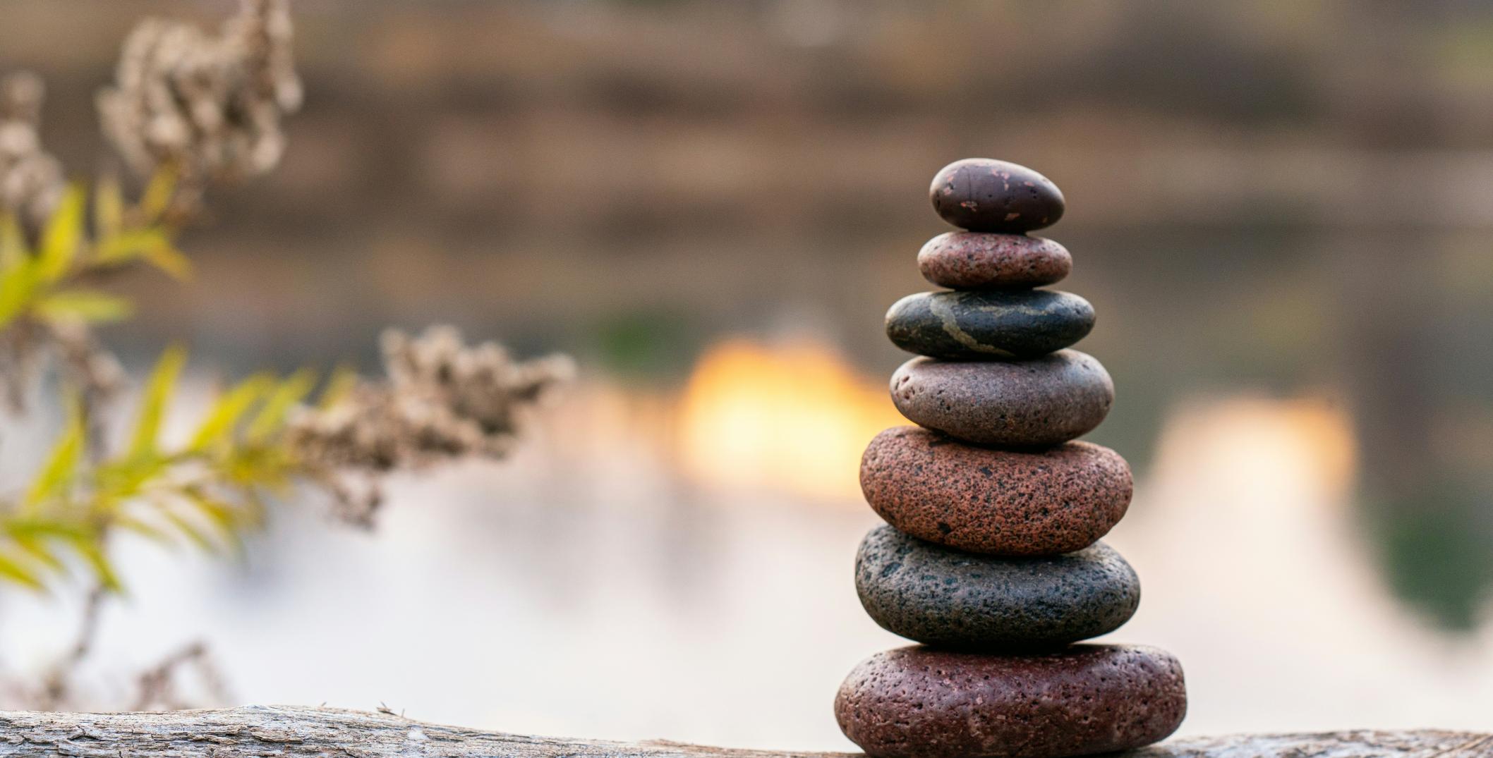Stacked rocks in foreground with water in background 