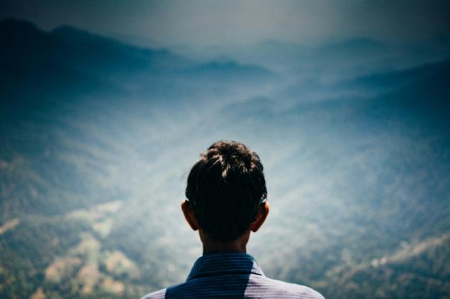 Back of man's head in found of mountain landscape