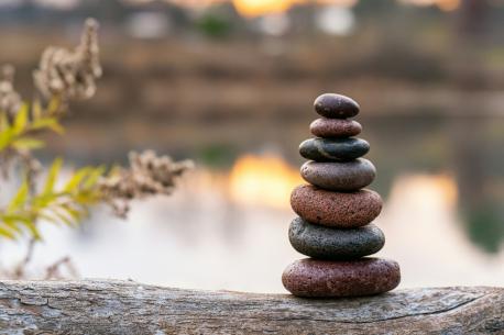 Stacked rocks in foreground with water in background 